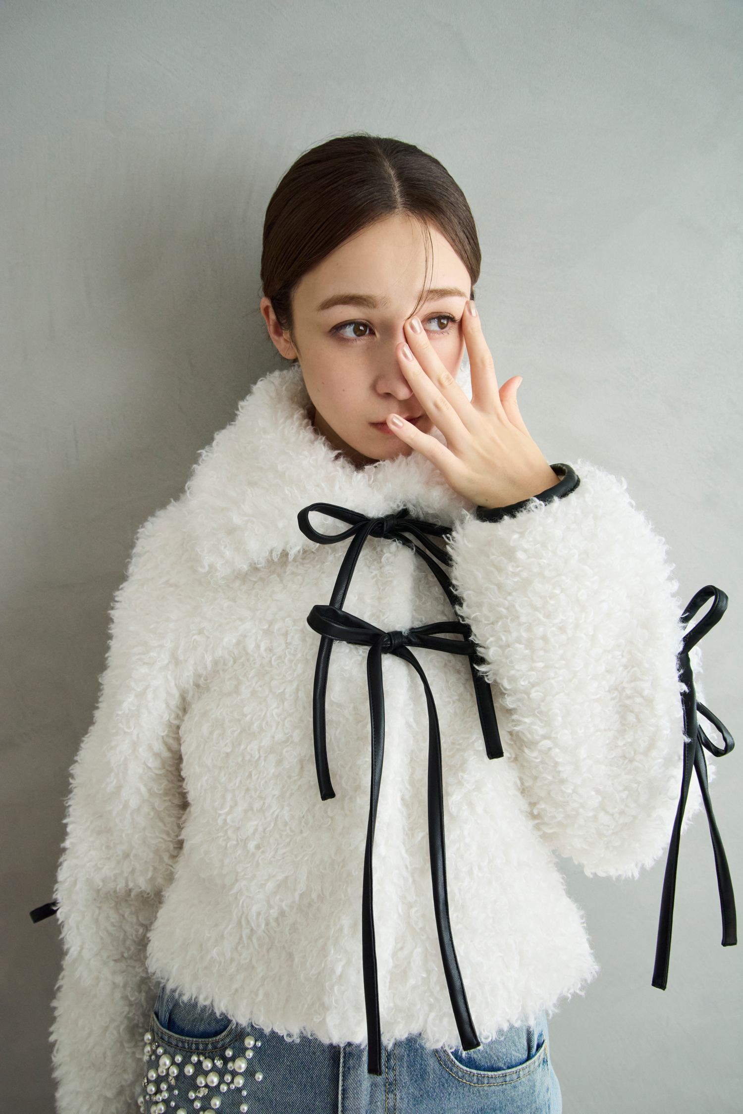 リボンボアファージャケット・FoxCashオフショルニットトップス・ハイウエストビジューデニムPTを着用した女性の画像