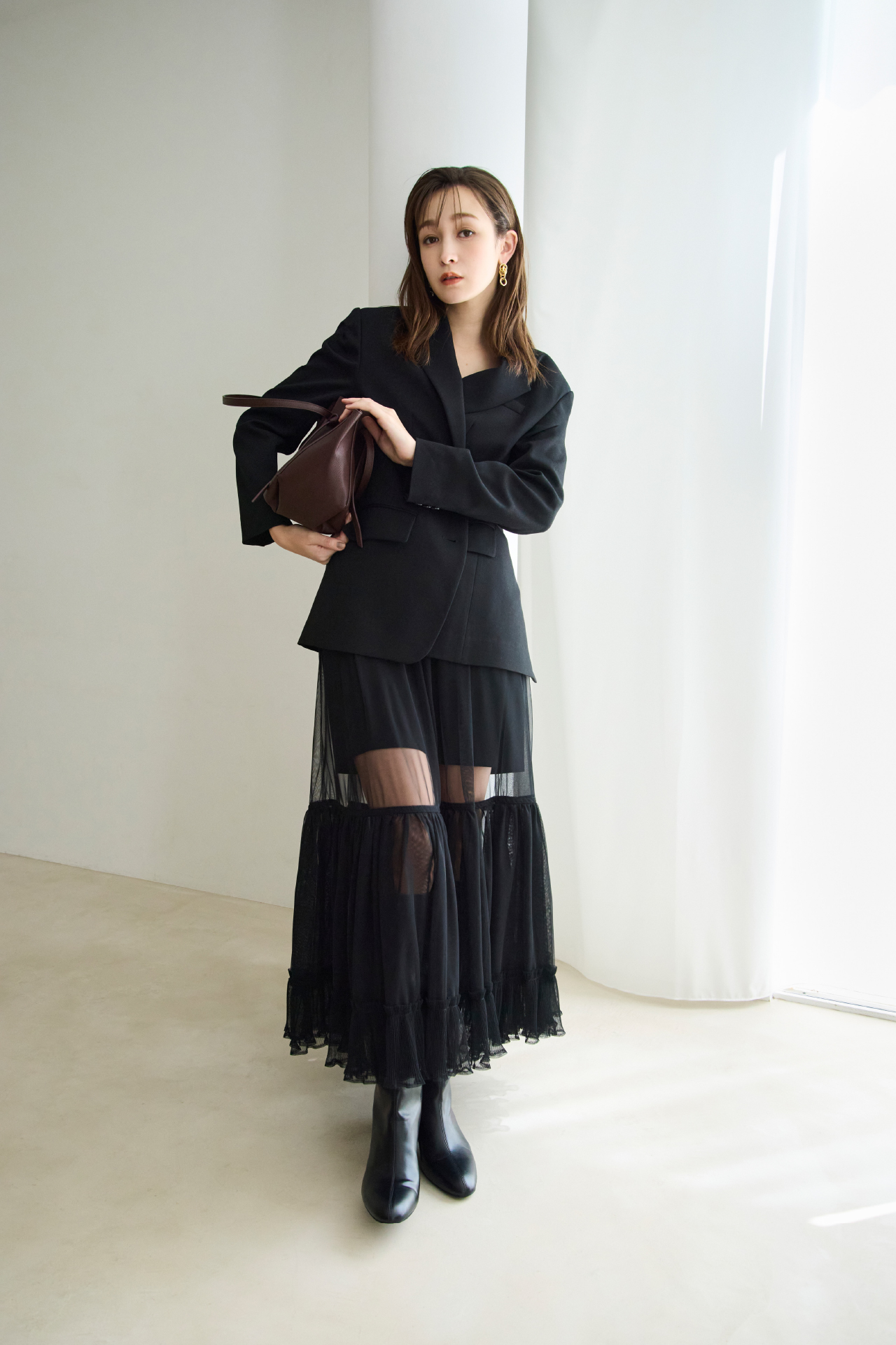 2WAY　BIGジャケット・プリーツヘム　チュールスカート・ベルトデザイントートバッグ・ラウンドトゥロングブーツを着用した女性の画像