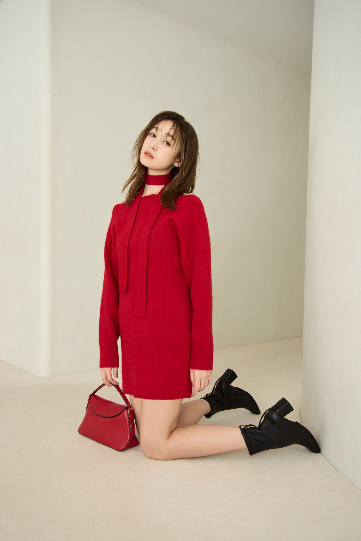 Fox Woolミニニットワンピース・ワンハンドルミディアムバッグ・ストレッチショートブーツを着用した女性の画像