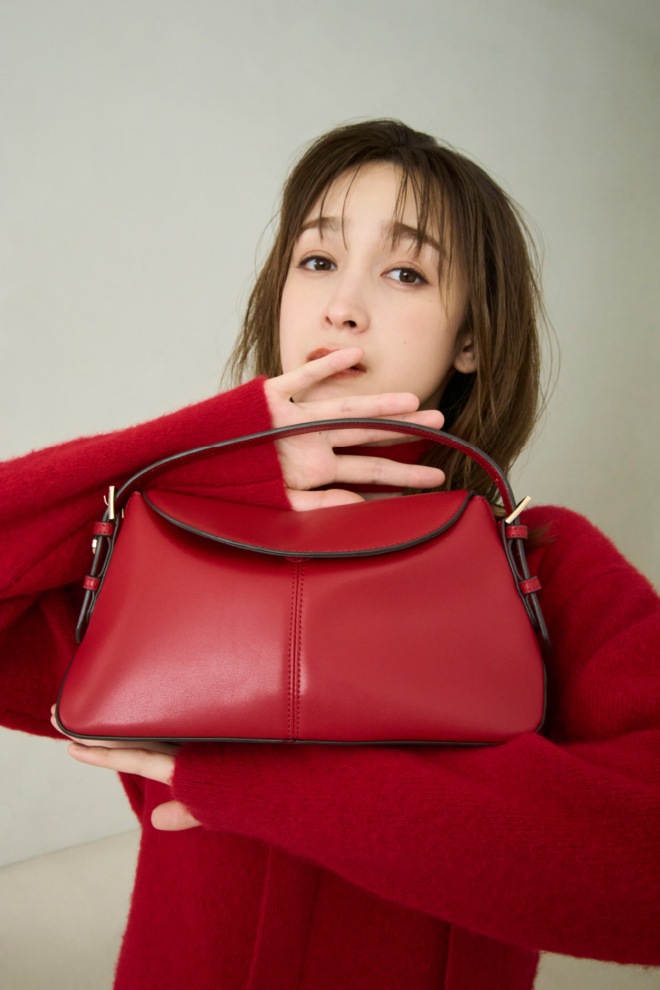 Fox Woolミニニットワンピース・ワンハンドルミディアムバッグを着用した女性の画像