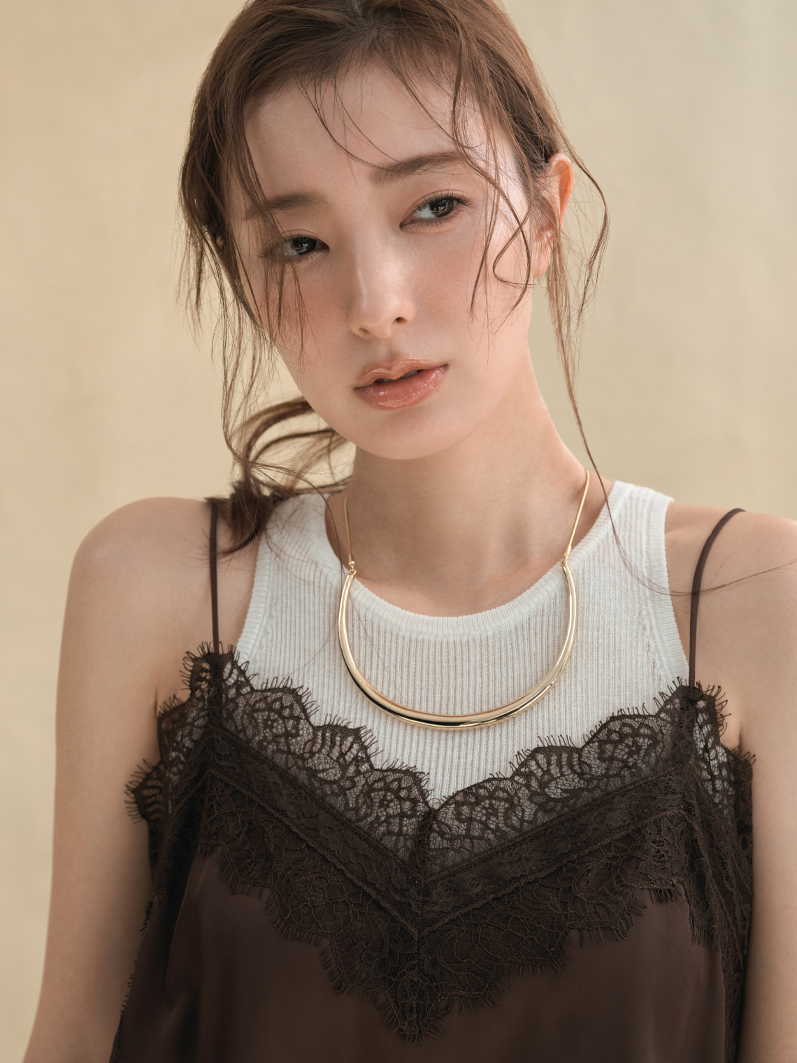 シアーリブニットレイヤードトップス・サイドスリットレーストリムキャミソール・セミシアーハイウエストパンツ・メタルチョーカーネックレスを着用した女性