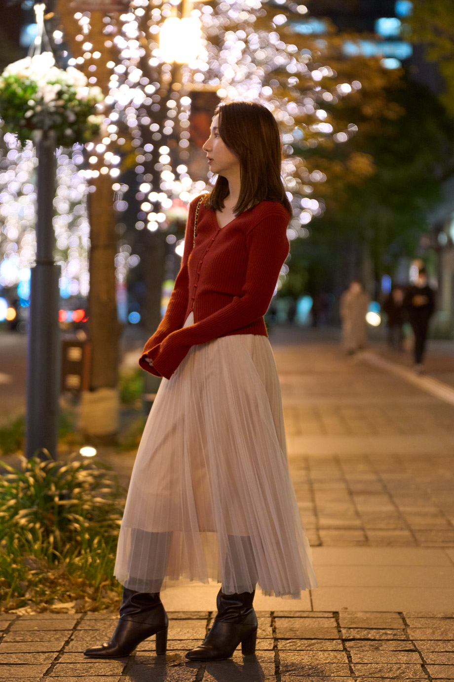 赤のニットドレス・黒のロングブーツを履いた女性