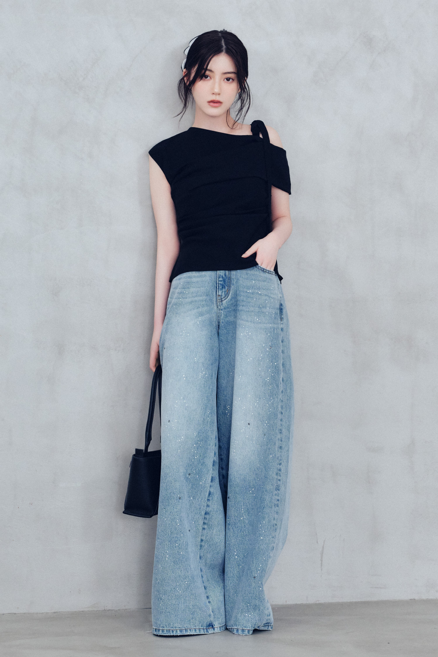 ワンサイドリボンアシメブラウス・ラインストーンセミワイドストレートデニムパンツ・シュシュクリップ・ベルトデザインレザートートバッグ・トングウェッジサンダルを着用した女性